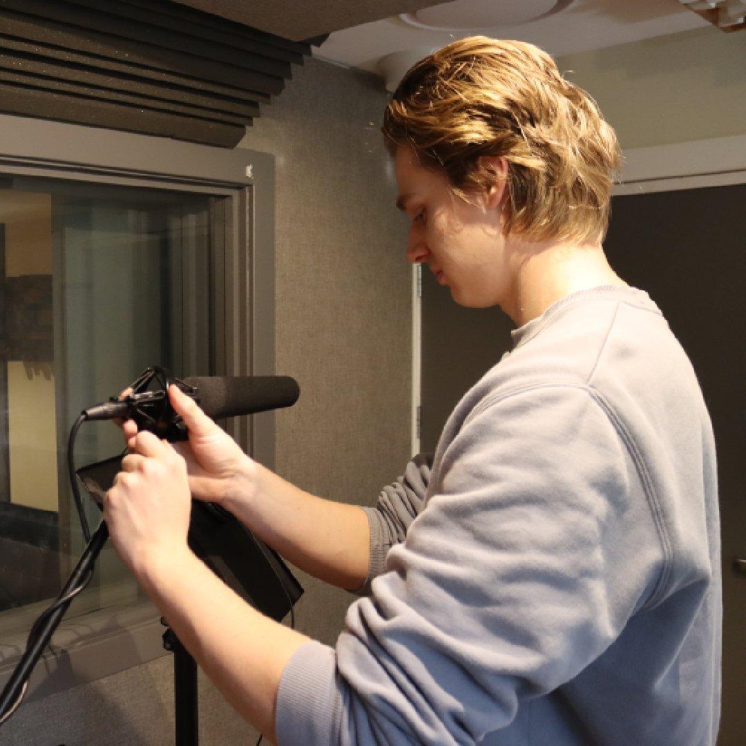 Zach Johnson setting up a microphone in the studio